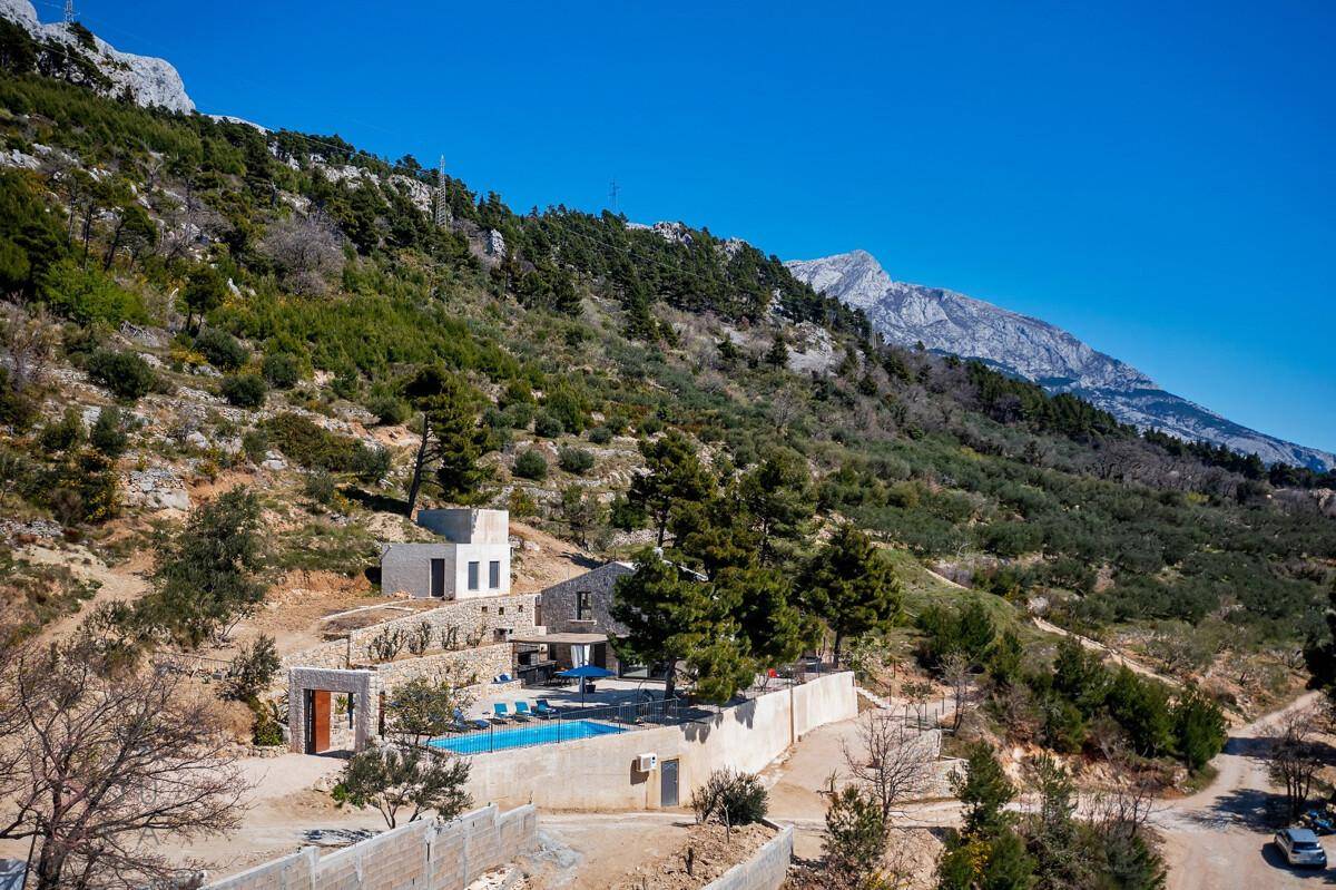 Malerische Ansicht der Villa in Hanglage mit Pool und beeindruckendem Bergpanorama.