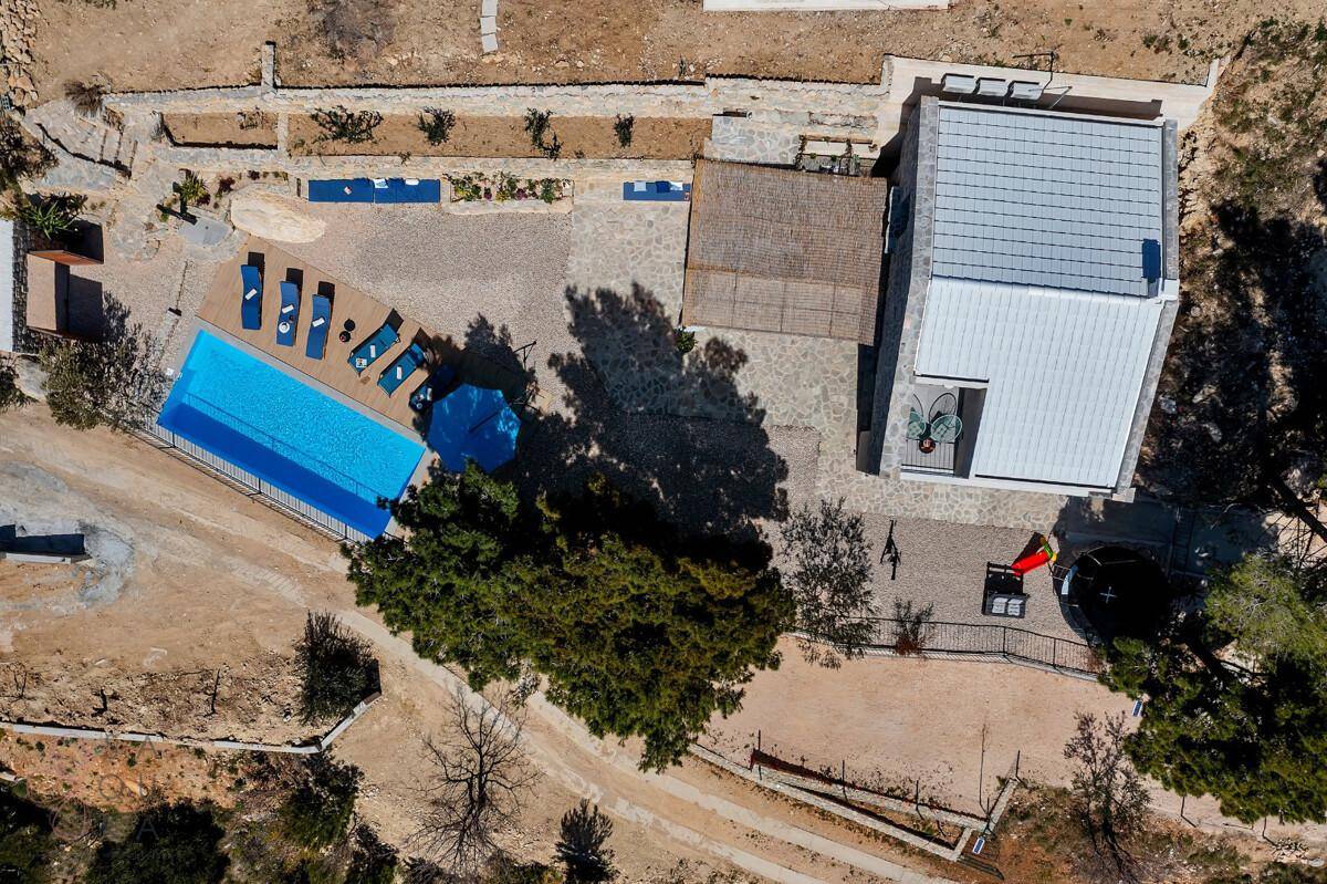 Draufsicht auf das Anwesen mit Pool, Terrasse und umliegender Landschaft.