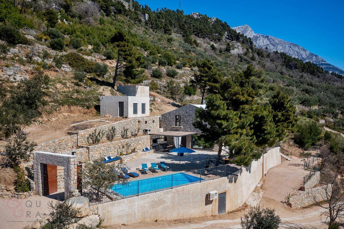 Malerische Ansicht der Villa in Hanglage mit Pool und beeindruckendem Bergpanorama.