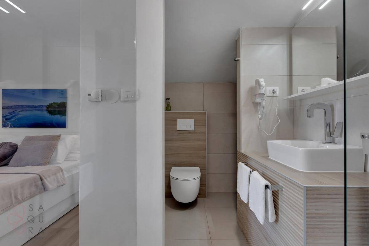 Modernes Badezimmer mit Dusche und WC, direkt vom Schlafzimmer zugänglich.