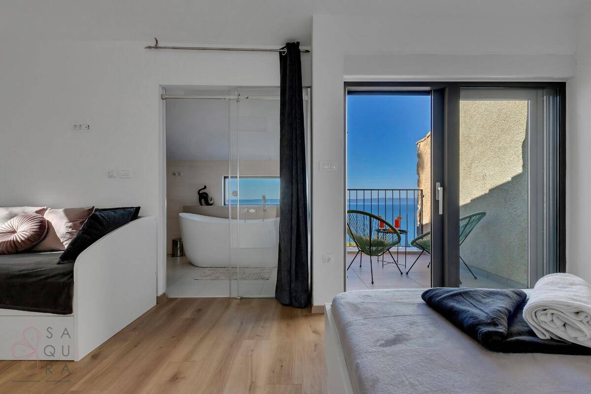 Helles Schlafzimmer mit Balkonzugang, Meerblick und modernem Design.