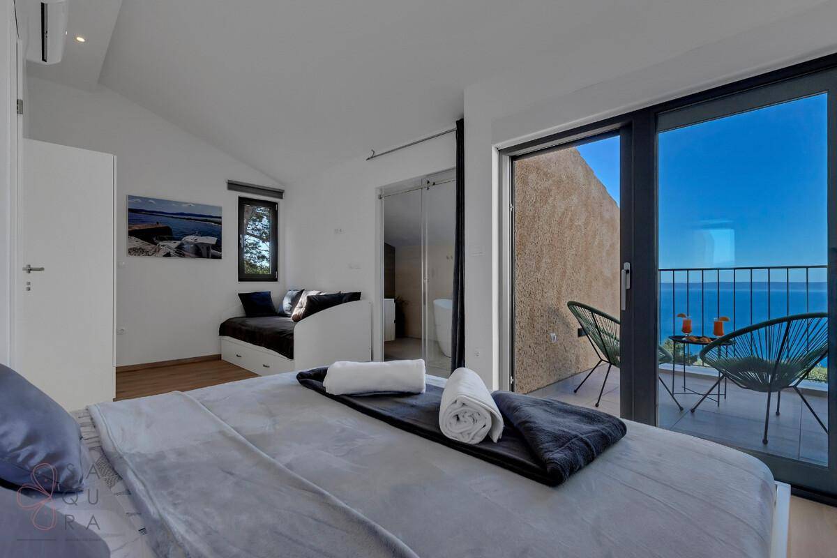 Helles Schlafzimmer mit Balkonzugang, Meerblick und modernem Design.