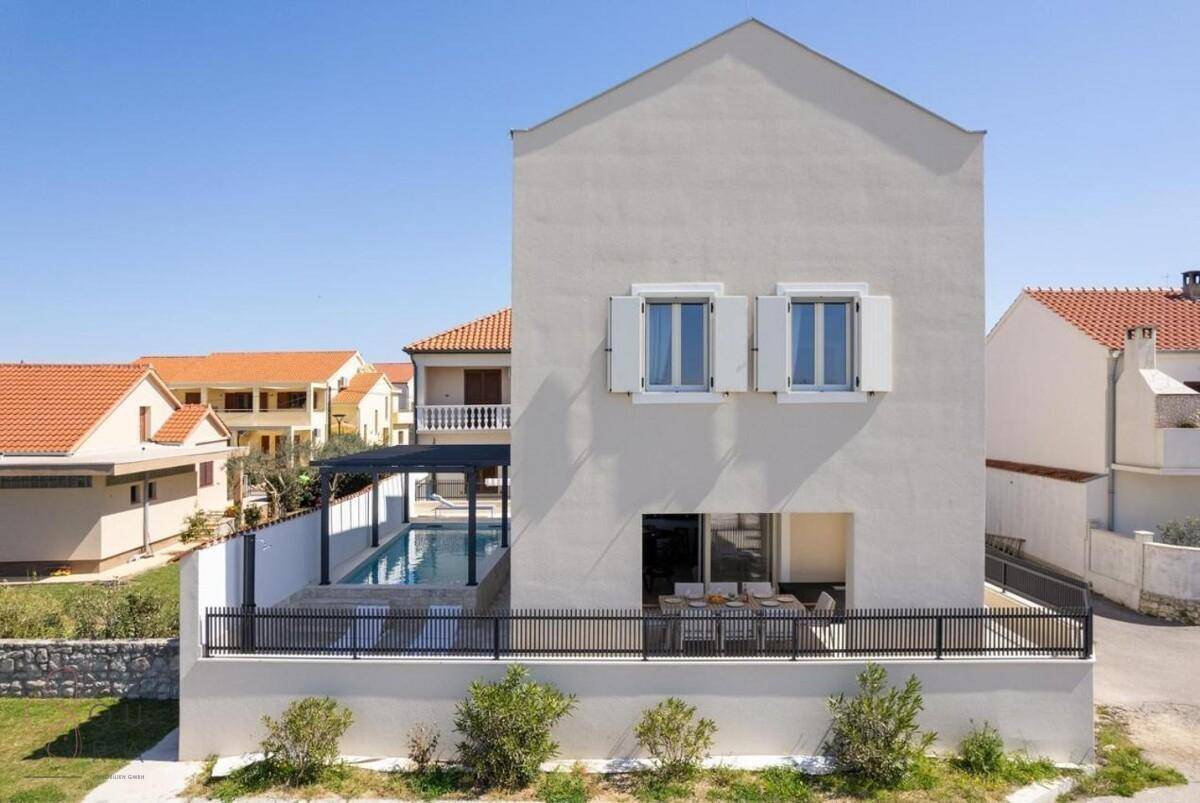 Ansicht der modernen Fassade des Gebäudes mit einem kleinen Pool und Essbereich im Freien.