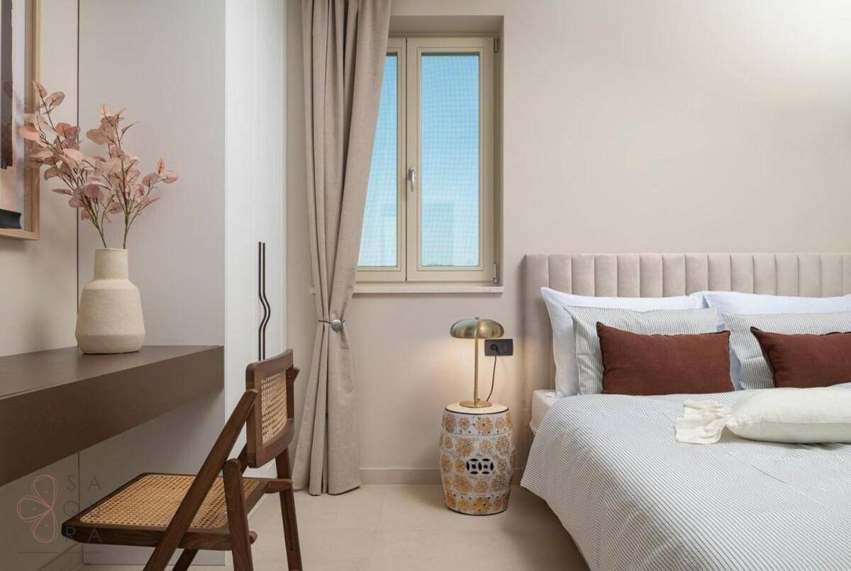 Helles Schlafzimmer mit bequemem Bett, kleinem Schreibtisch und natürlichem Lichteinfall.