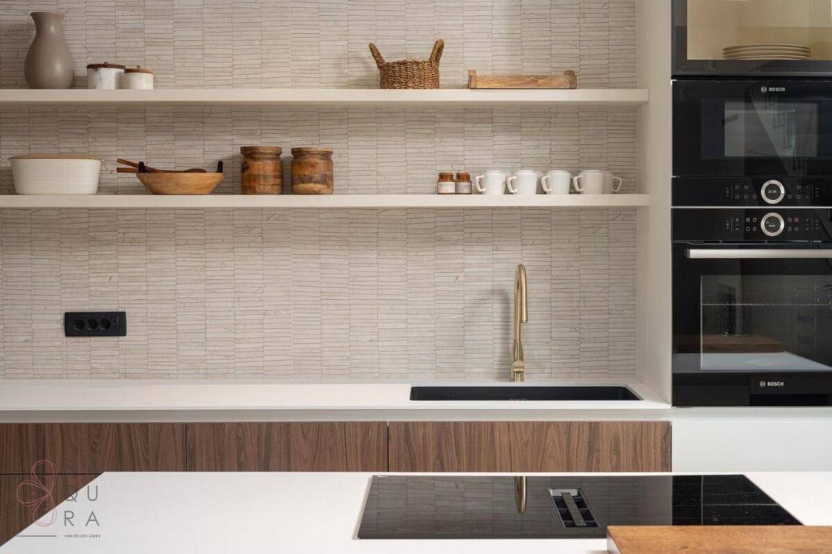 Küchenarbeitsplatte mit Spüle, modernem Wasserhahn und hochwertigen Einbaugeräten.