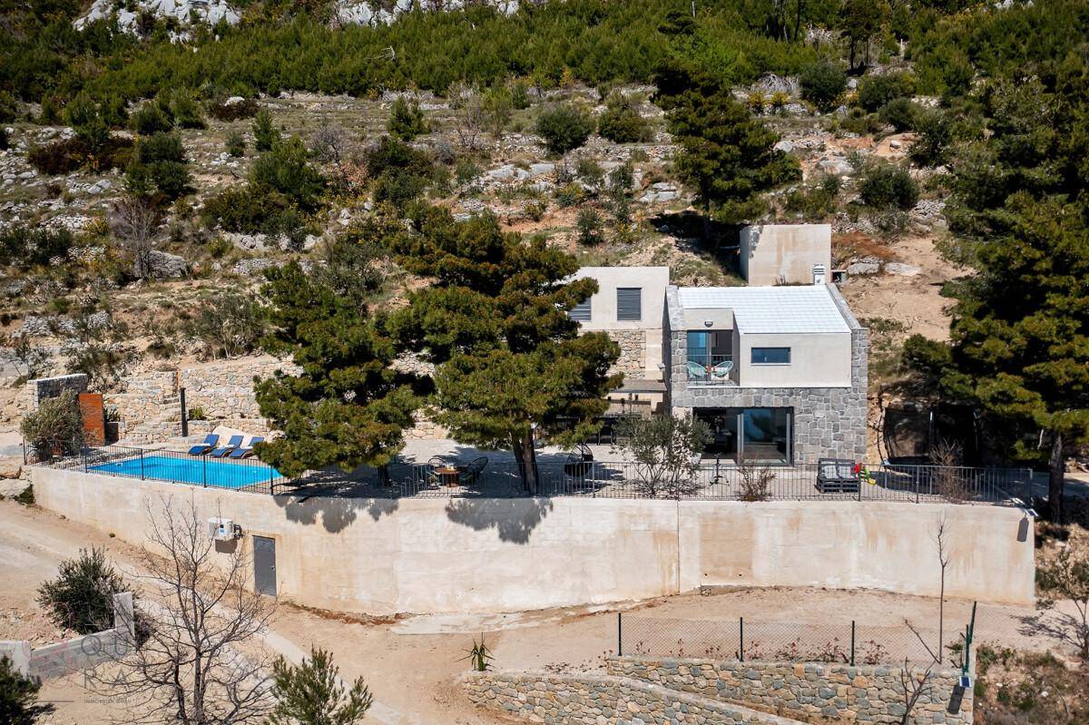 Weitläufige Ansicht des Anwesens mit Pool und Steinfassaden, eingebettet in die mediterrane Landschaft.