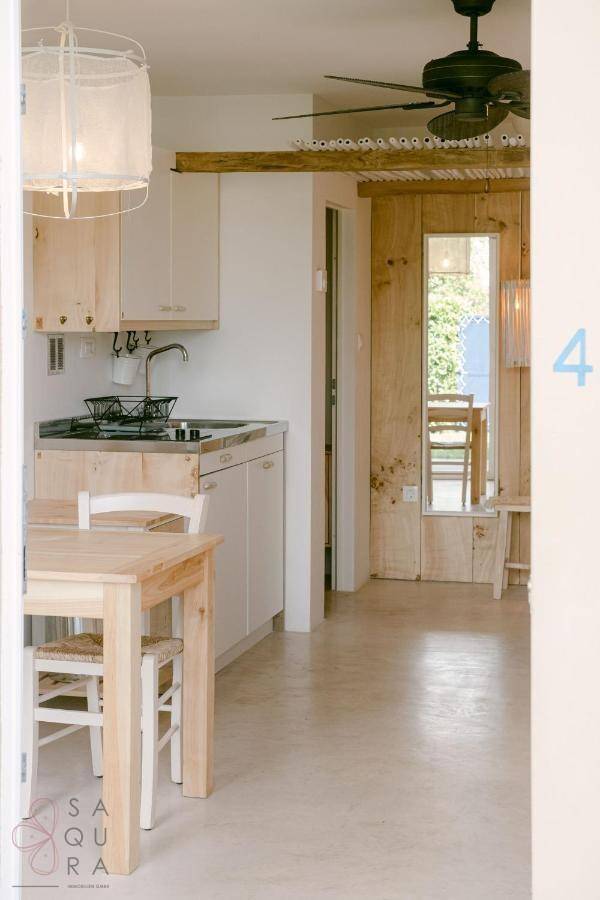 Helle Küchenzeile in einem Studio-Apartment mit Holzelementen und Deckenventilator.