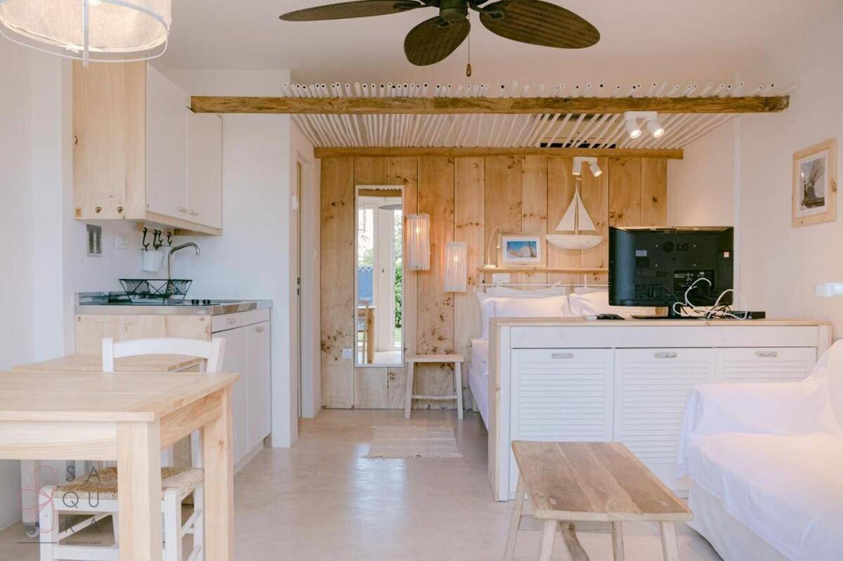 Helles Studio-Apartment mit Holzwänden, Küchenzeile und Schlafbereich.