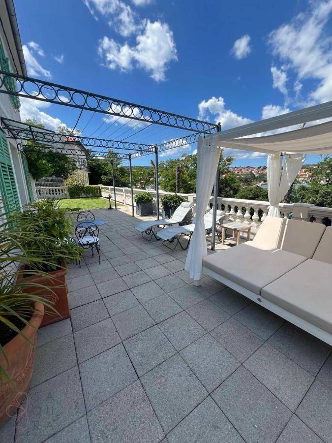 Große Sonnenterrasse mit Liegeflächen, Pergola und Blick auf die Umgebung.