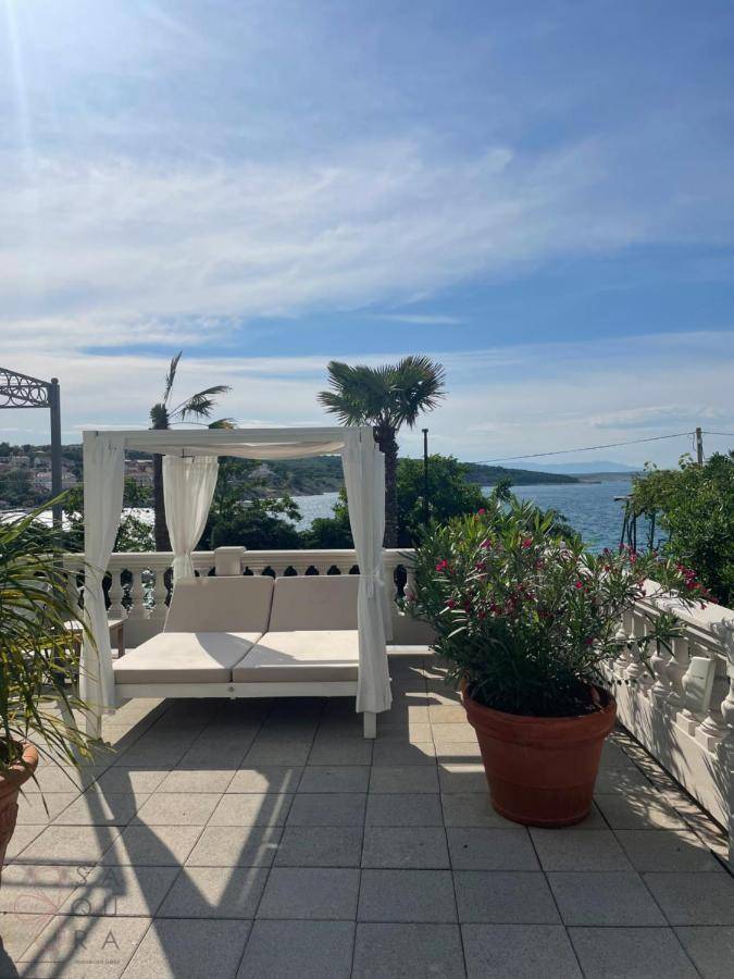 Sonniger Terrassenbereich mit luxuriösem Tagesbett und weitem Blick auf das Meer.