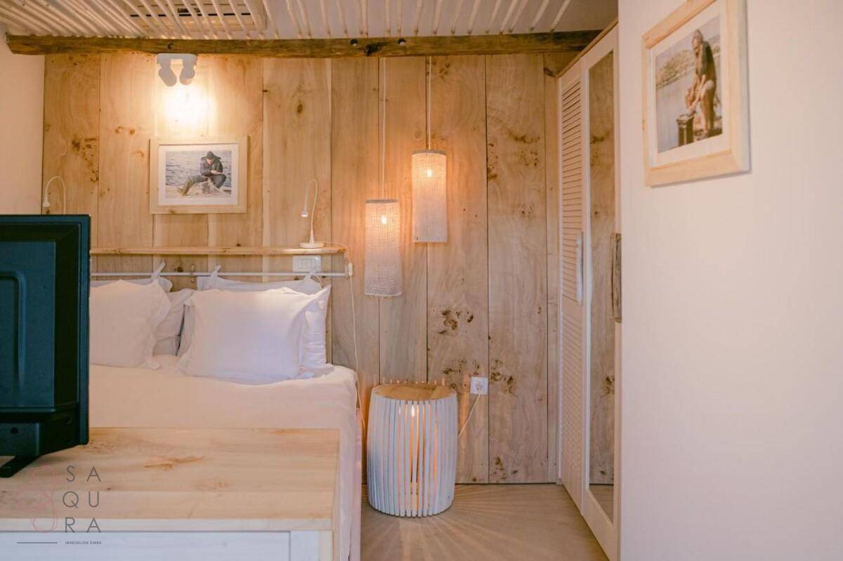 Gemütliches Schlafzimmer mit Holzwandverkleidung, Nachttischen und indirekter Beleuchtung.