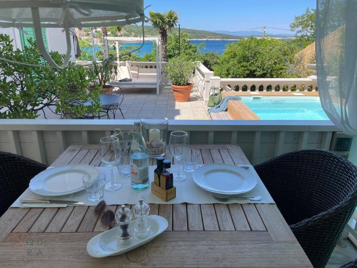 Gedeckter Esstisch im Freien mit Blick auf den Pool und das weite Meer.