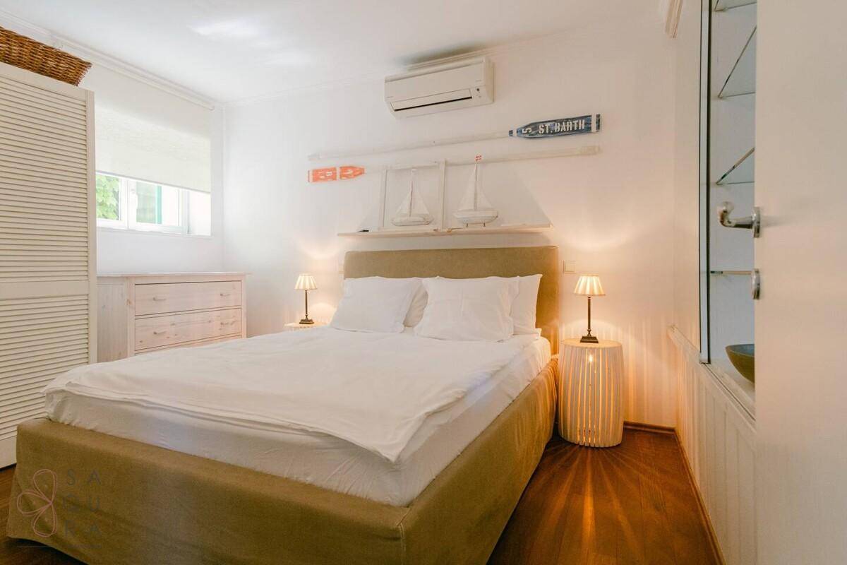 Helles Schlafzimmer mit Doppelbett, Klimaanlage und maritimer Wanddekoration.