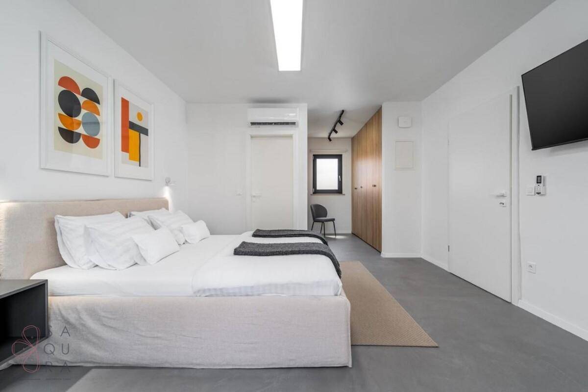 Modernes Schlafzimmer mit Doppelbett, Klimaanlage und Holzelementen.
