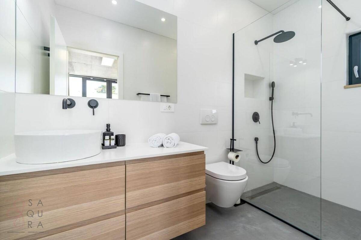 Modernes Badezimmer mit begehbarer Dusche, Waschtisch und Wand-WC.