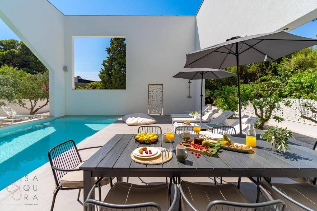 Reich gedeckter Tisch im Freien für ein Frühstück oder Mittagessen am Pool.