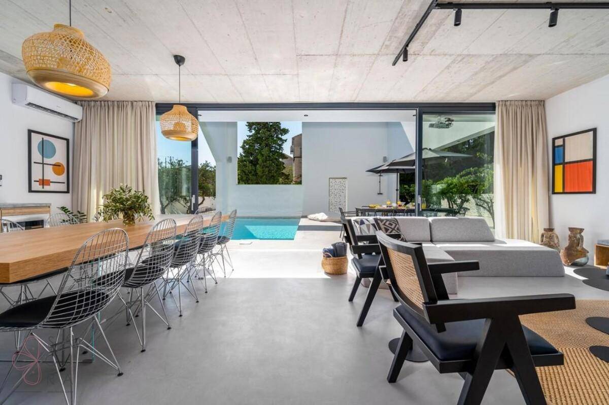 Geräumiger Wohn- und Essbereich mit moderner Einrichtung und Blick auf den Pool.