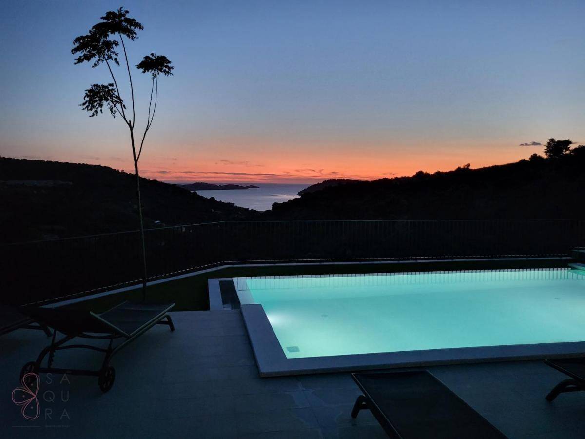 Ruhiger Poolbereich bei Sonnenuntergang mit Blick auf das Meer und den farbenfrohen Himmel.