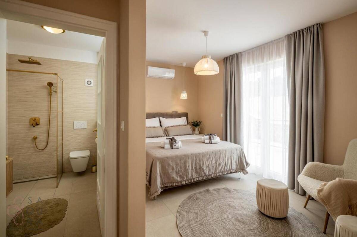 Gemütliches Schlafzimmer mit Doppelbett, Klimaanlage und Zugang zu einem modernen Badezimmer.