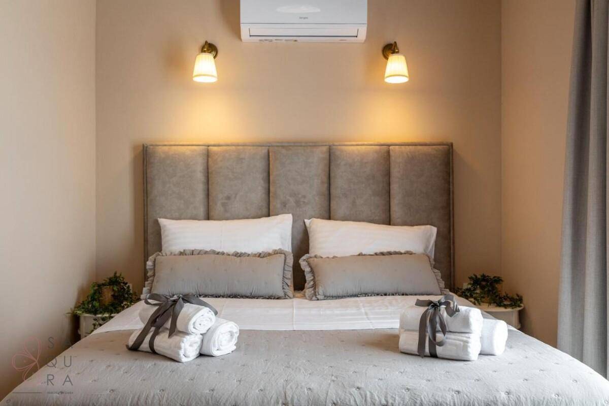 Komfortables Doppelbett mit gepolstertem Kopfteil und stilvollen Wandlampen, schafft eine gemütliche Atmosphäre.