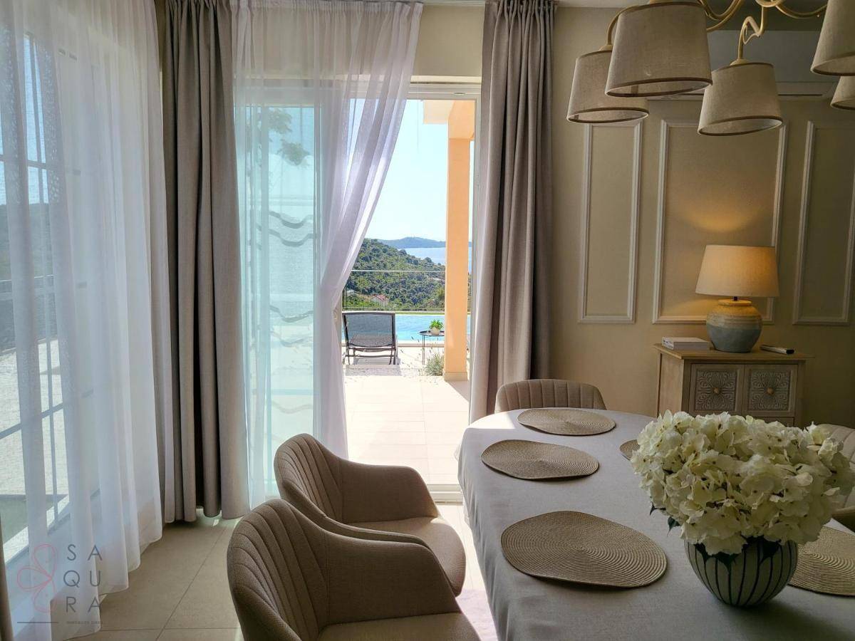 Eleganter Essbereich mit großem Fenster und direktem Blick auf den Pool und die umliegende Landschaft.