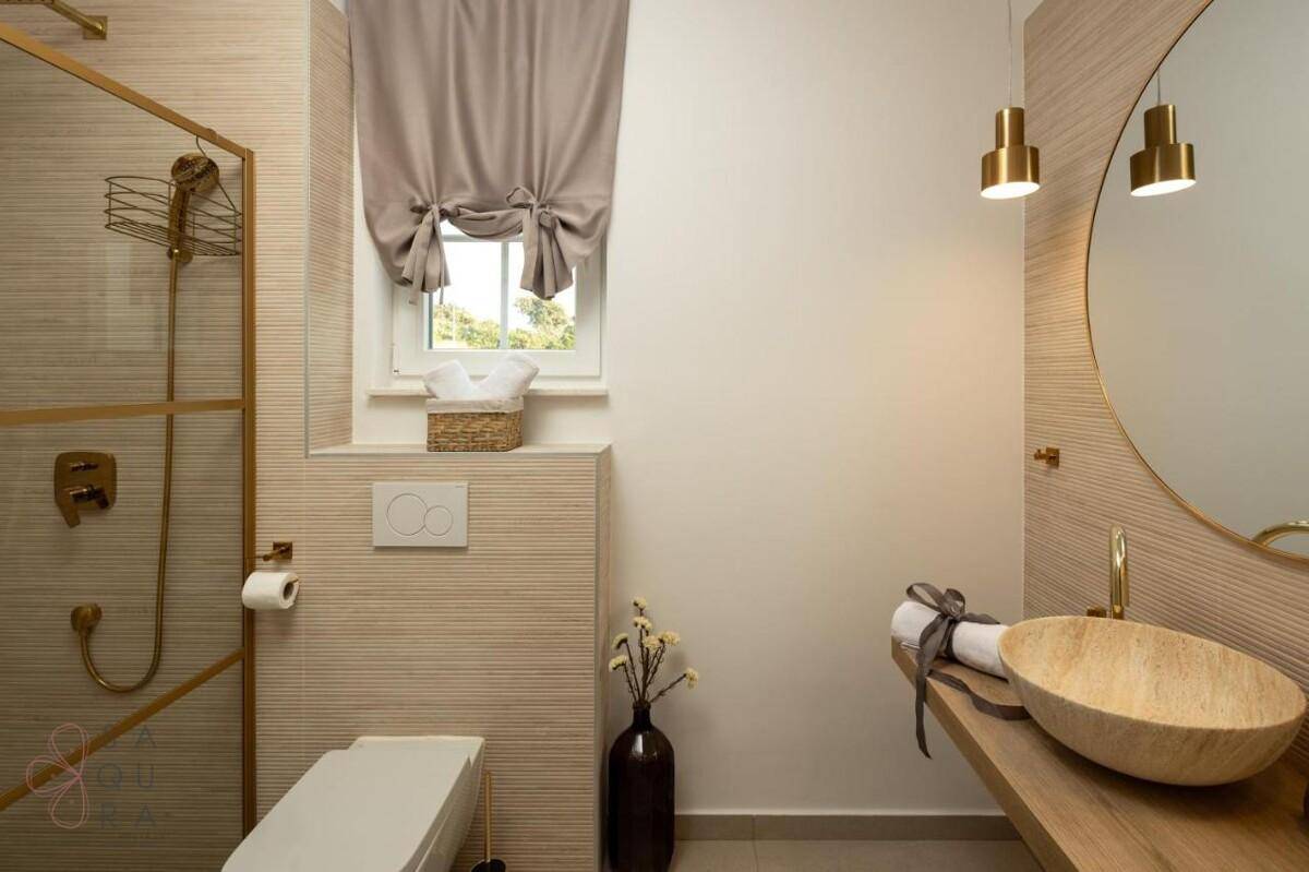 Stilvolles Badezimmer mit modernem Waschtisch, begehbarer Dusche und einem Fenster für natürliches Licht.