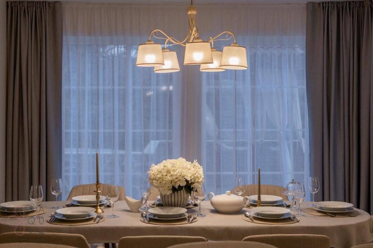 Festlich gedeckter Esstisch mit elegantem Geschirr und Blumenarrangement, bereit für Gäste.