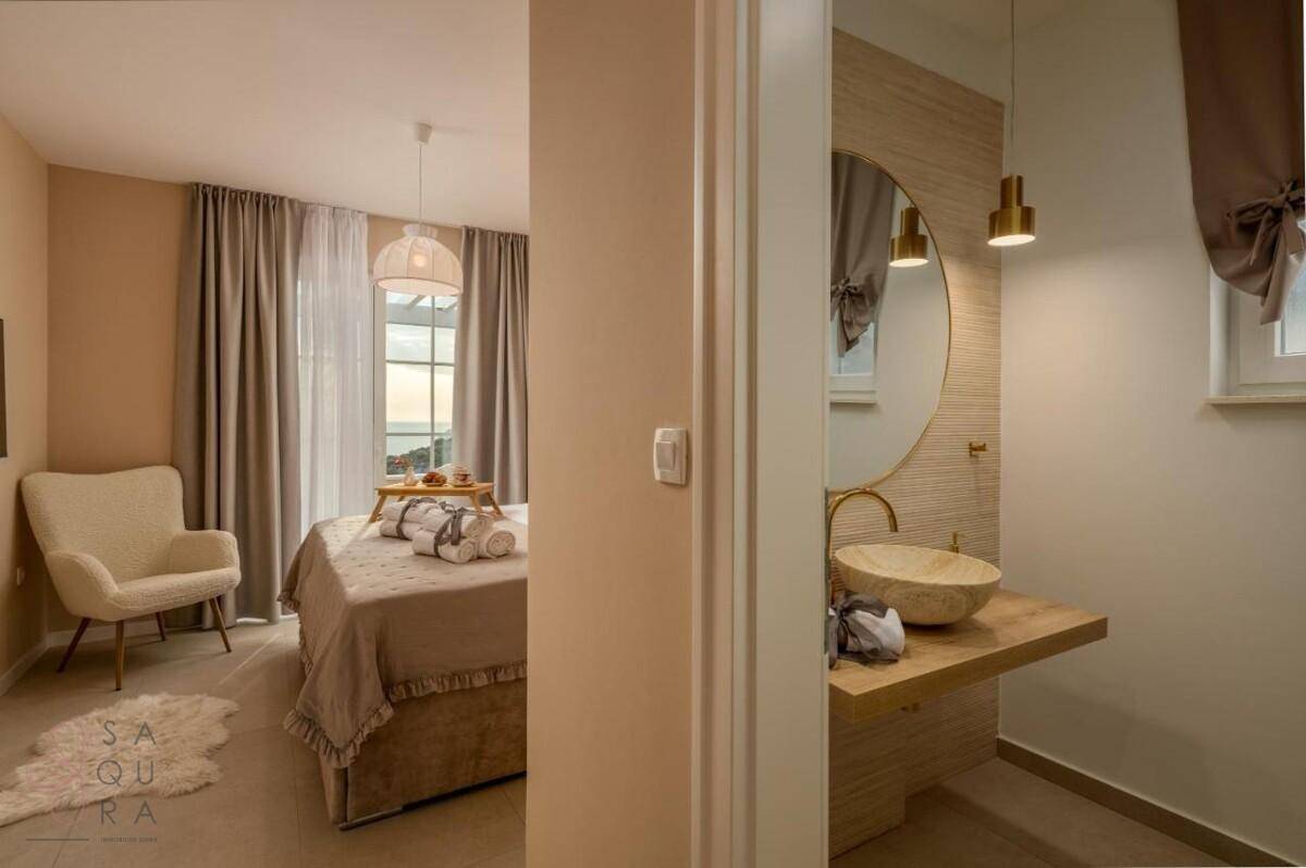 Komfortables Schlafzimmer mit Blick auf das Meer und angrenzendem, modern ausgestattetem Badezimmer.