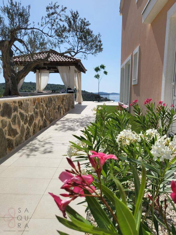 Mediterraner Gartenweg mit blühenden Pflanzen und einem charmanten Pavillon im Hintergrund.