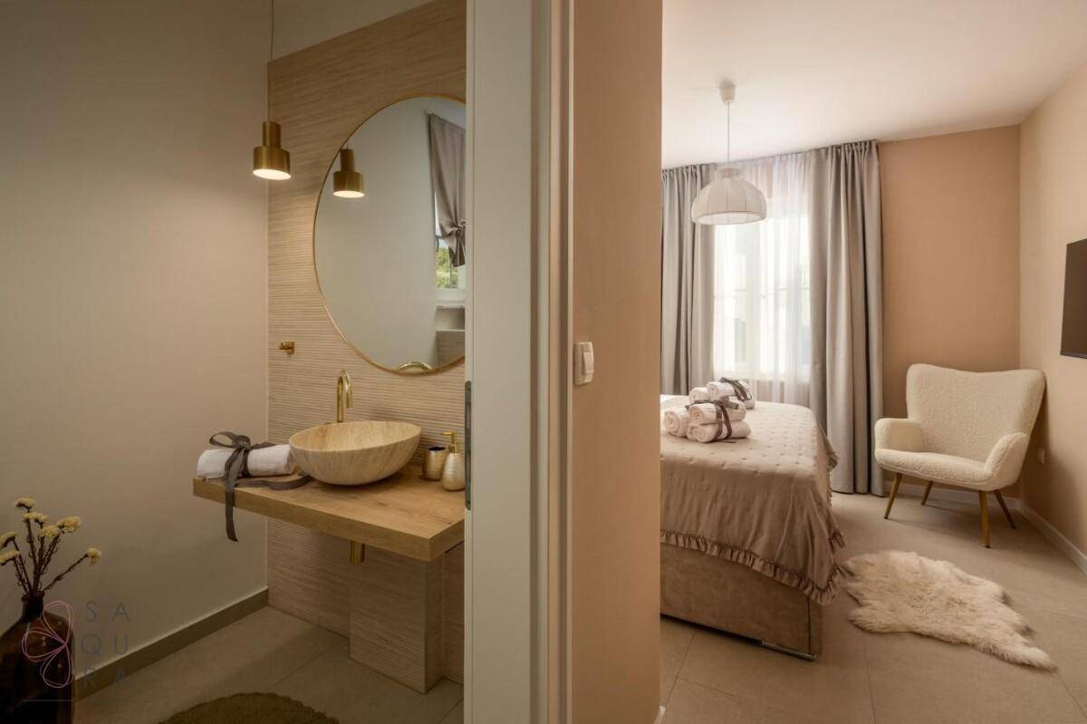 Helles Schlafzimmer mit Zugang zu einem stilvollen Badezimmer, beide modern und komfortabel eingerichtet.