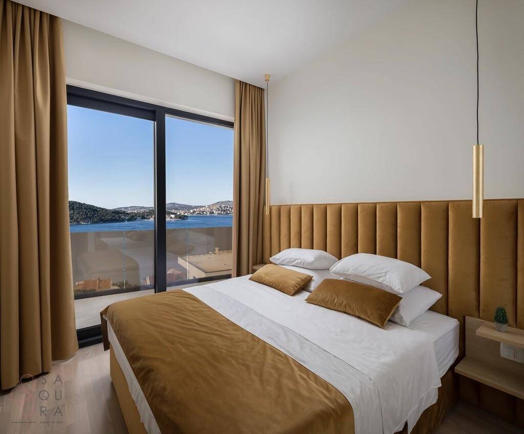 Schlafzimmer mit großem Fenster, das einen weiten Blick auf das Meer bietet.