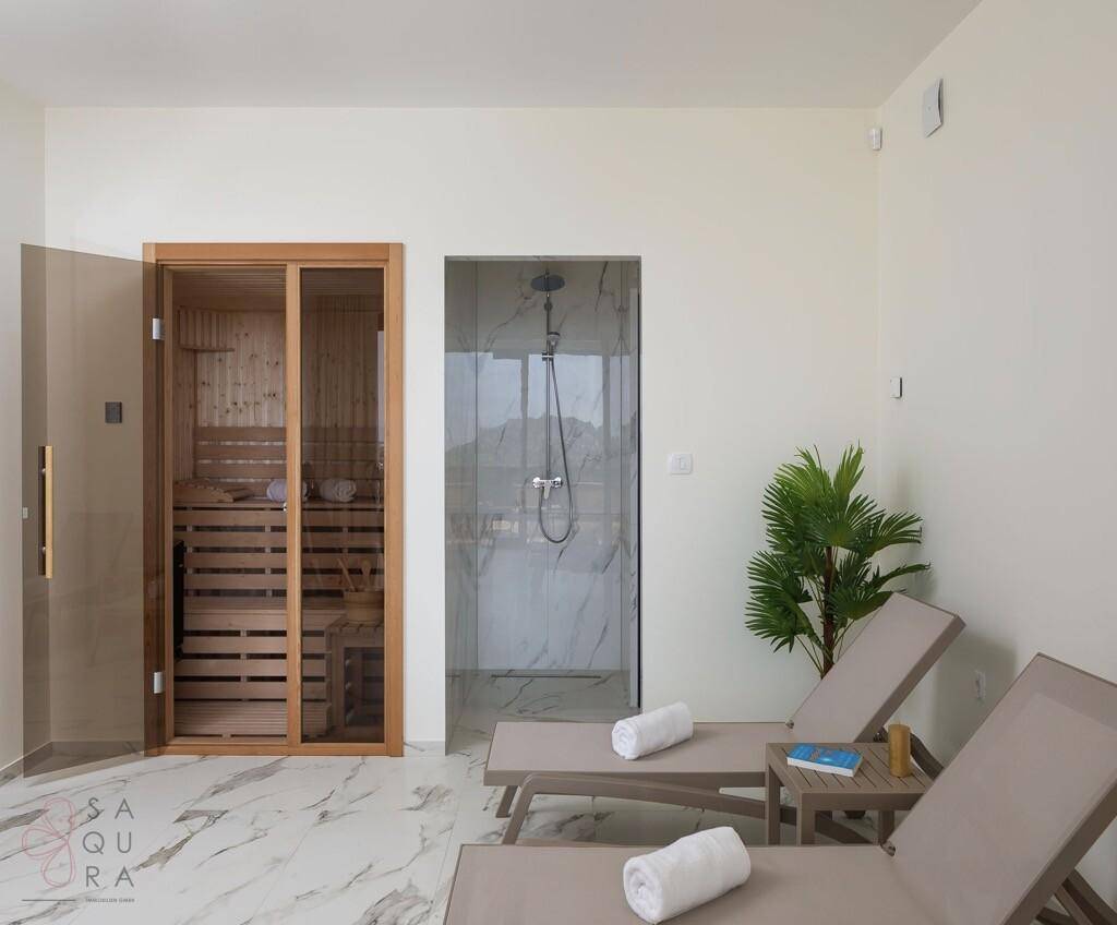 Entspannender Wellnessbereich mit Sauna, Dusche und Liegen zum Erholen.