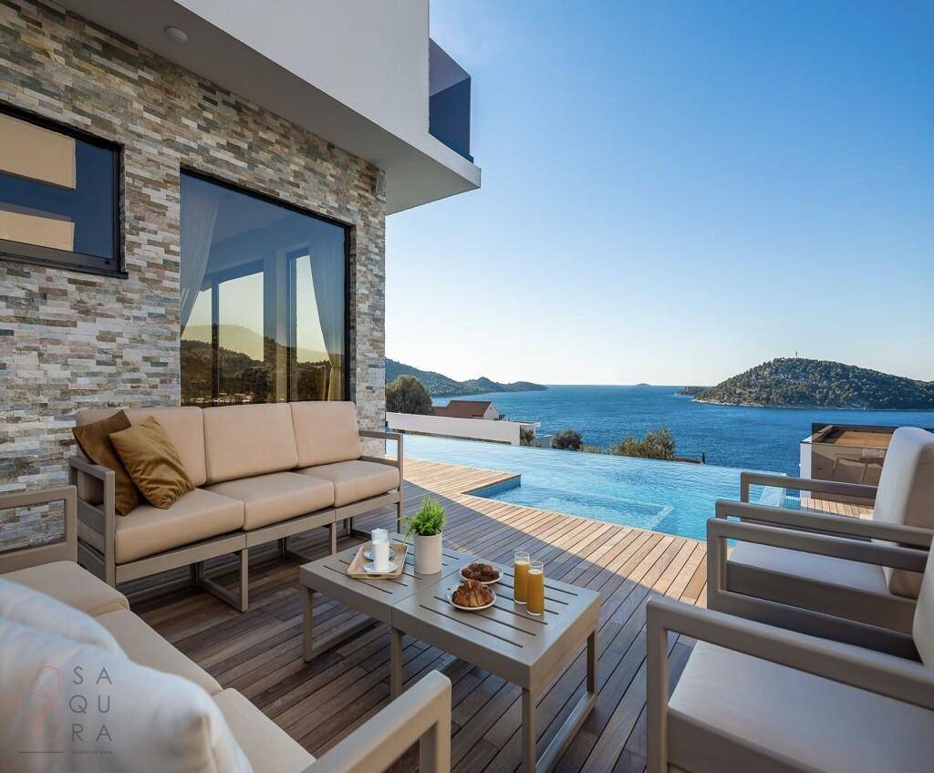 Gemütliche Sitzecke auf der Terrasse mit Blick auf den Infinity-Pool und das Meer.