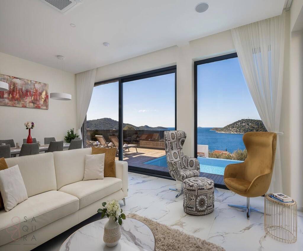 Gemütlicher Wohnbereich mit bequemen Sofas, Meerblick und Zugang zur Terrasse.