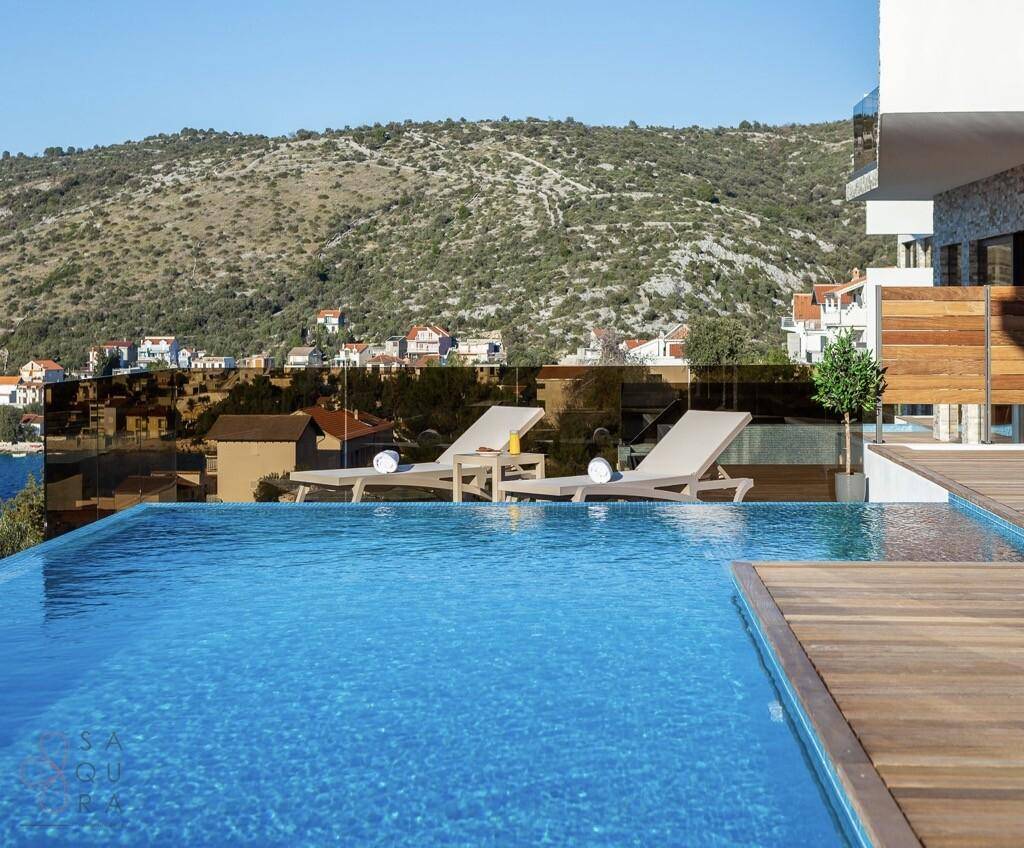 Infinity-Pool mit Blick auf die umliegenden Hügel und die Küstenlandschaft.
