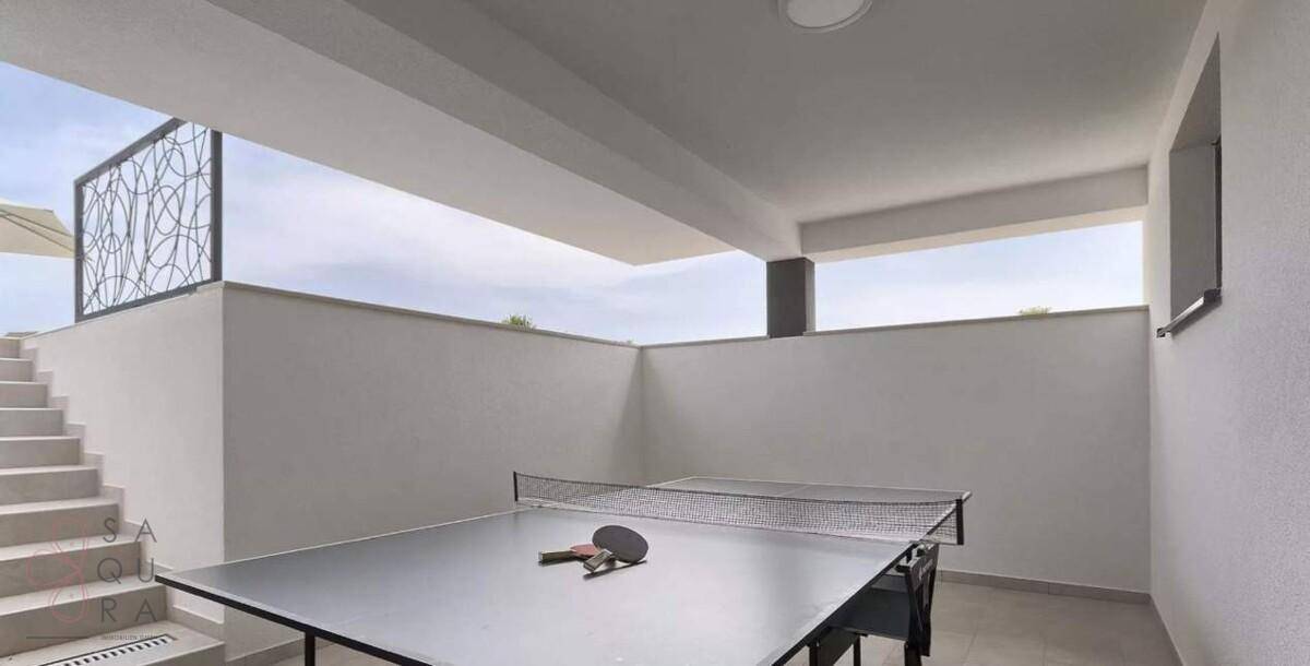 Überdachter Freizeitbereich mit Tischtennisplatte und Zugang zur Außentreppe.