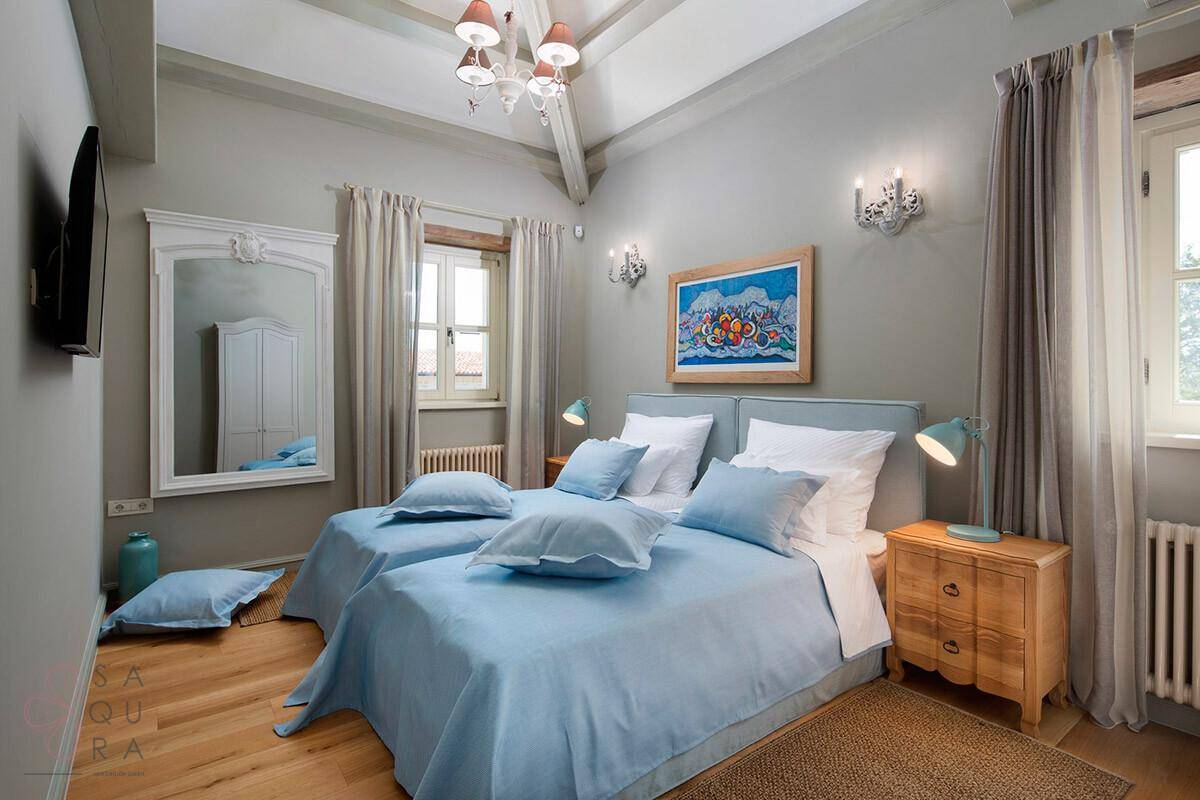 Gemütliches Schlafzimmer mit zwei Einzelbetten, Holzboden und traditioneller Einrichtung.