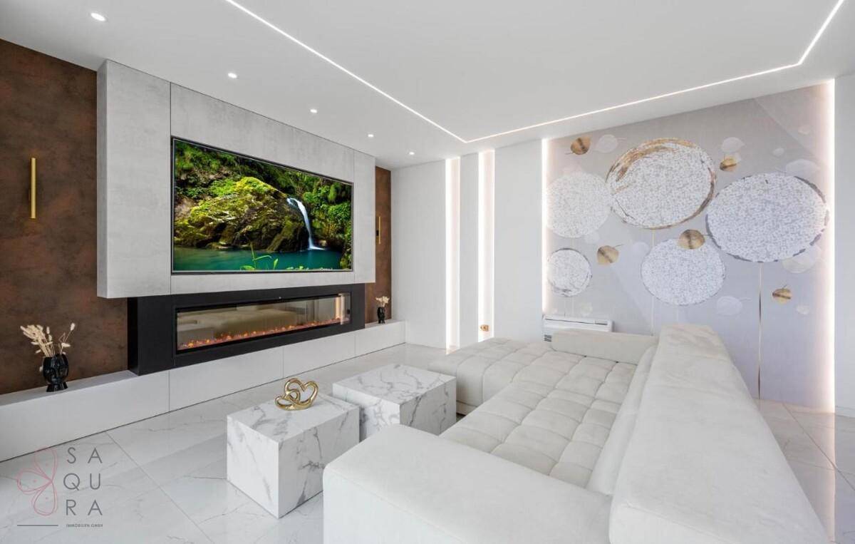 Elegantes Wohnzimmer mit bequemer Couch, Marmor-Couchtischen und integriertem Wandkamin.