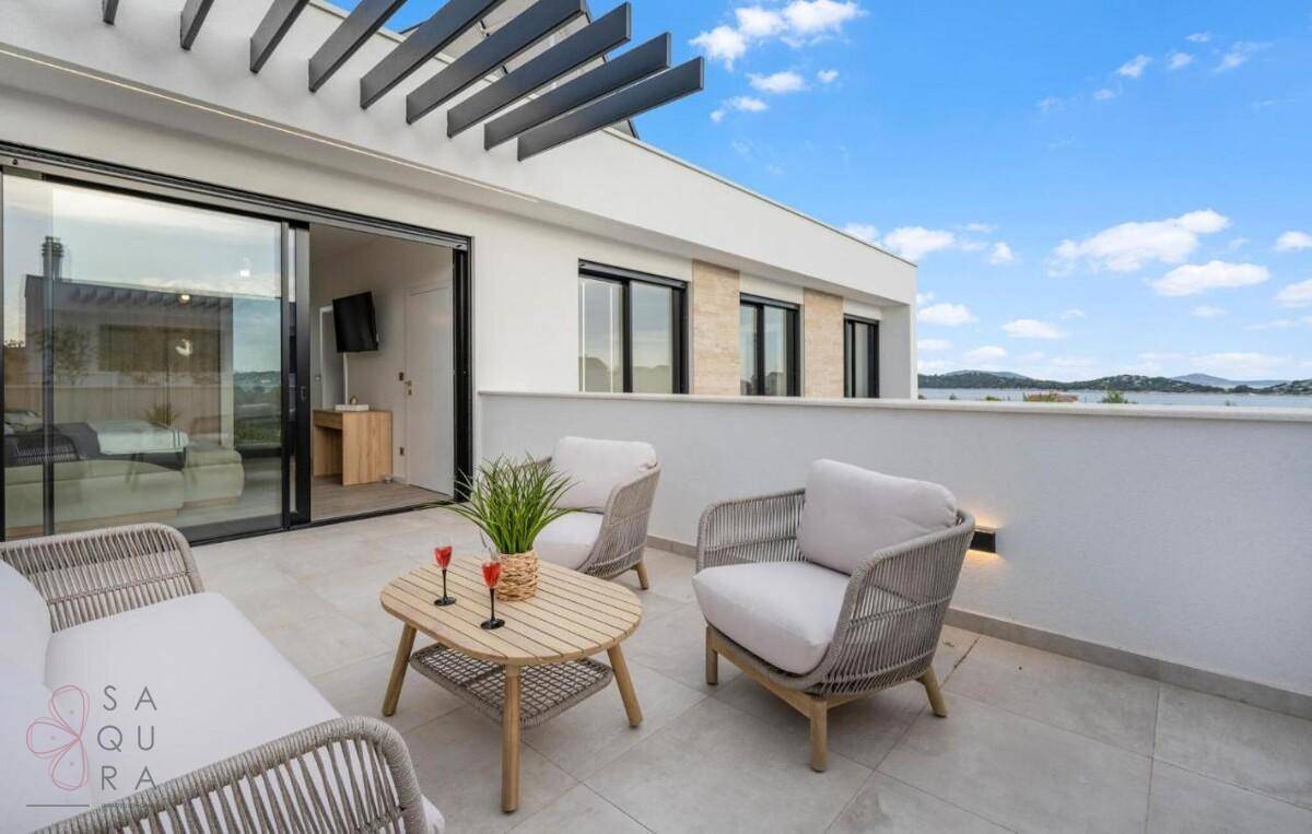 Gemütlicher Balkon mit modernen Lounge-Möbeln und weitem Blick auf die Umgebung und das Meer.