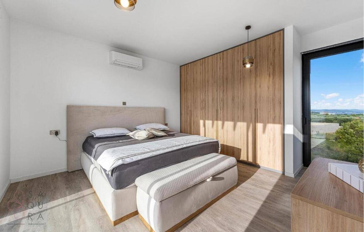Geräumiges Schlafzimmer mit Holzeinbauschränken, Doppelbett und großem Fenster.