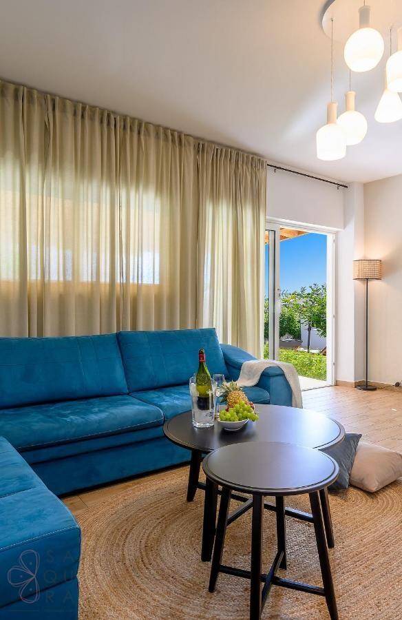 Helles Wohnzimmer mit blauem Sofa, Holzboden und Zugang zum Garten.