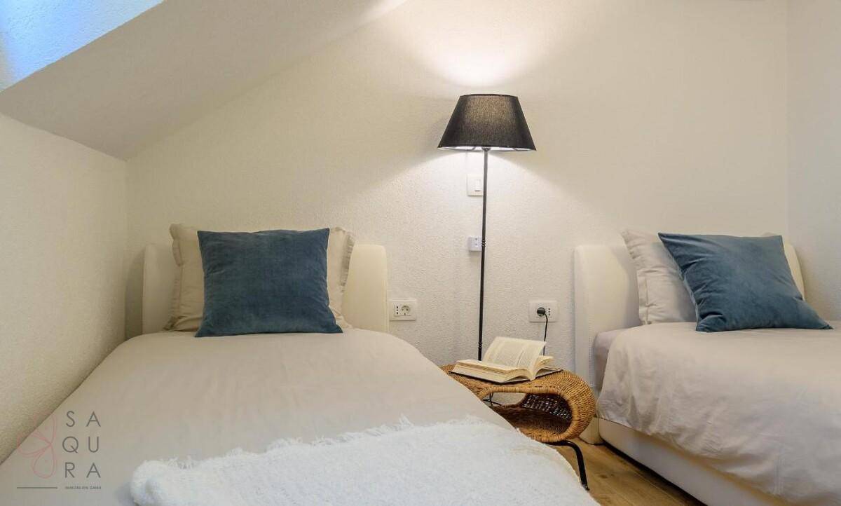 Gemütliches Schlafzimmer im Dachgeschoss mit Einzelbetten und schräger Decke.