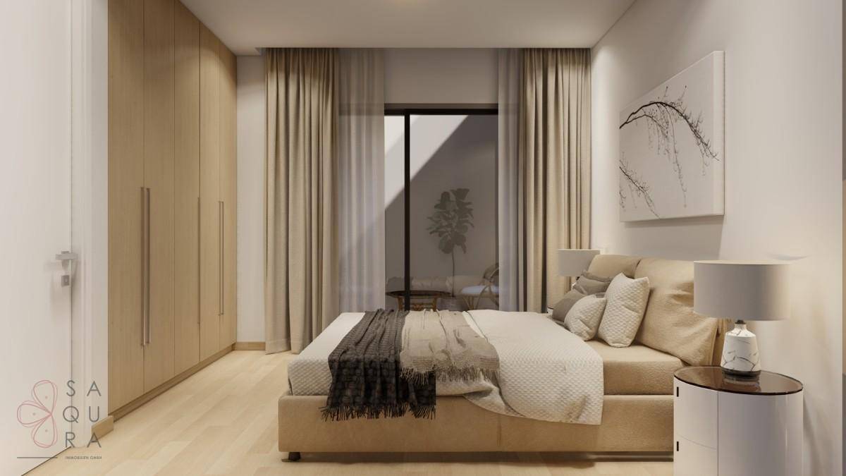 Geräumiges Schlafzimmer mit Doppelbett, Einbauschränken und Blick auf den Innenhof.