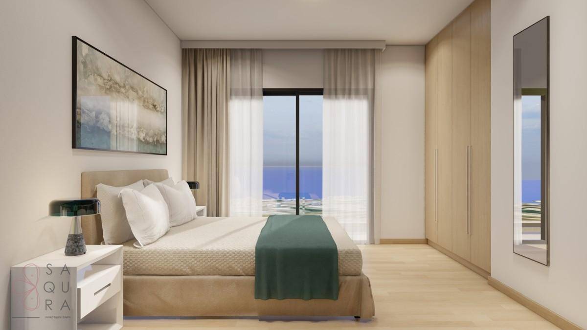 Helles Schlafzimmer mit Meerblick, Doppelbett und integrierten Kleiderschränken.