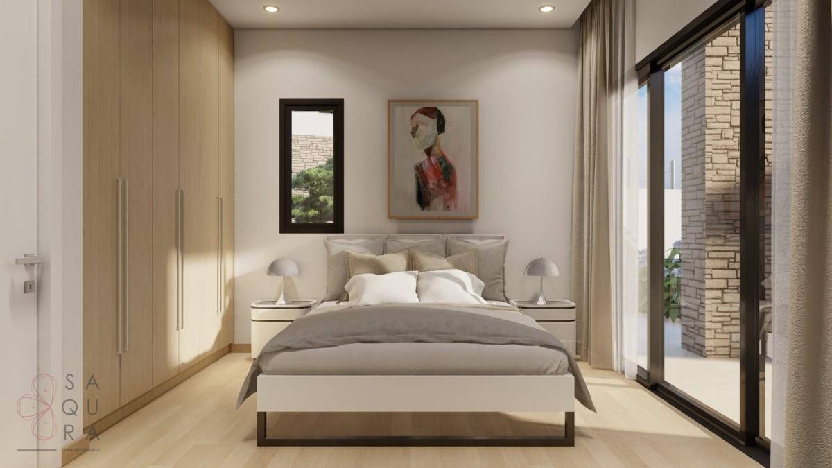 Helles Schlafzimmer mit Doppelbett, Einbauschränken und großem Fenster für viel Tageslicht.