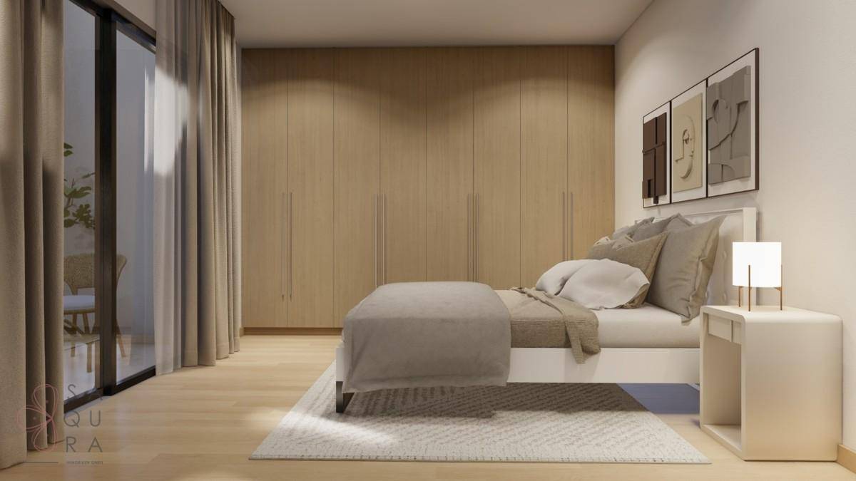 Helles Schlafzimmer mit Doppelbett, integrierten Kleiderschränken und Zugang zum Außenbereich.