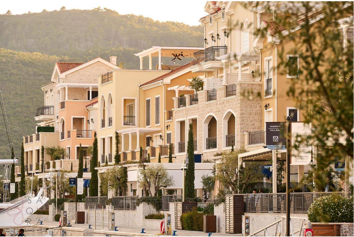 Mediterrane Architektur von Wohngebäuden entlang der Küste mit Balkonen und Steinverkleidungen.