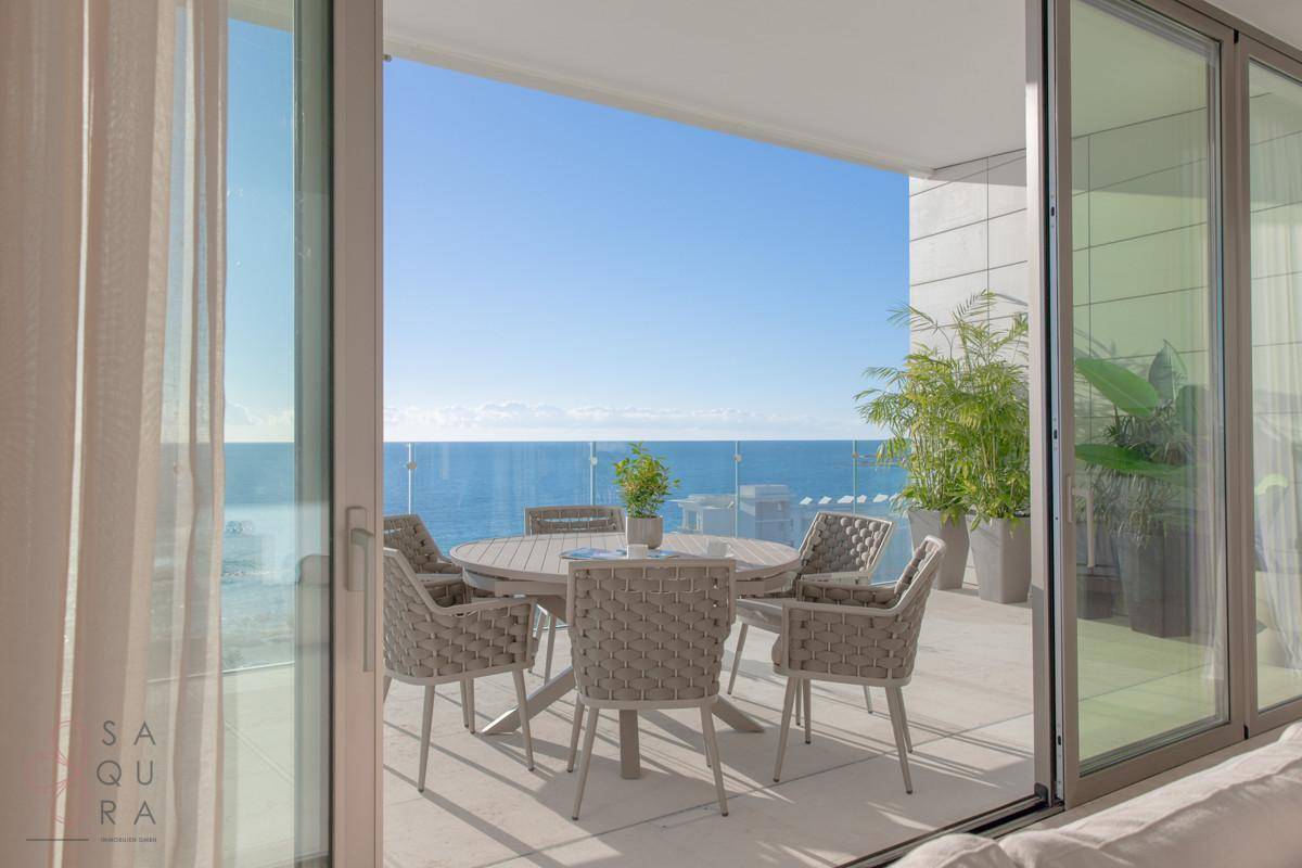 Geräumige Terrasse mit Meerblick, ausgestattet mit modernen Outdoor-Möbeln und Pflanzen.