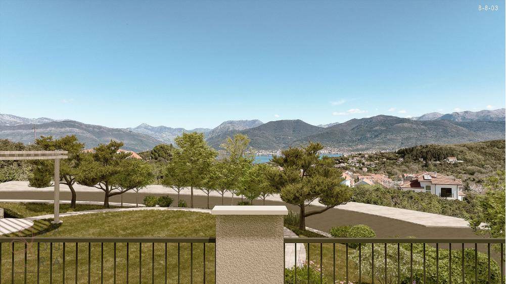 Weitläufiger Blick von einem Balkon auf grüne Hügel, Berge und das ferne Meer.