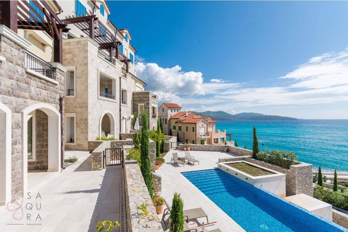 Infinity-Pool mit Liegestühlen und atemberaubendem Panoramablick auf das Meer und die Küstenlandschaft.